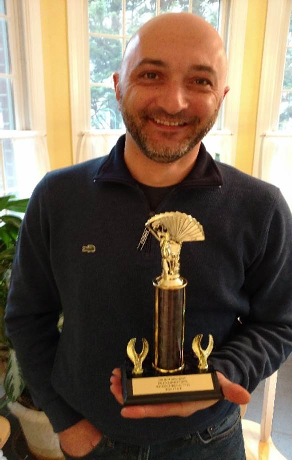A person holding a trophy

Description automatically generated